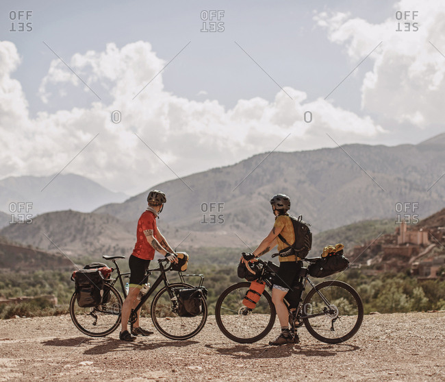 Atlas Mountains, Morocco - April 3, 2019: A couple of cyclists look at the view of the atlas mountains, morocco