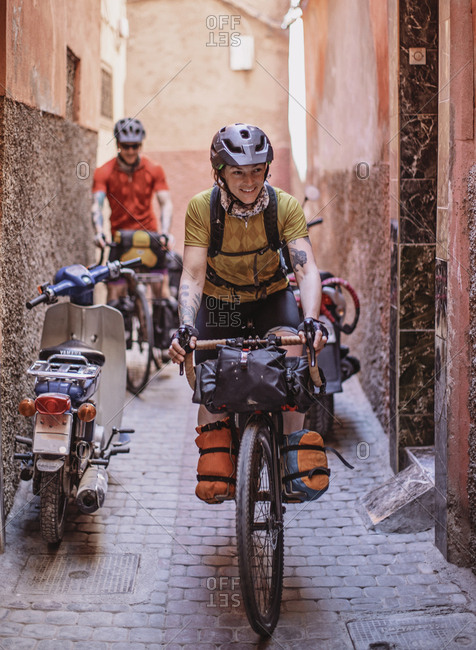 Morocco, Marrakesh-Safi, Marrakesh - April 11, 2019: Two cyclists ride their bikes through the narrow streets of marrakesh