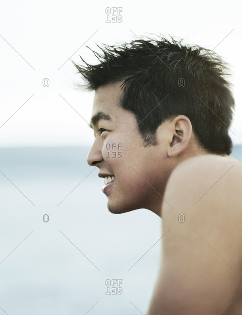 Side View Of Worried Man Sitting On Bed At Home stock photo