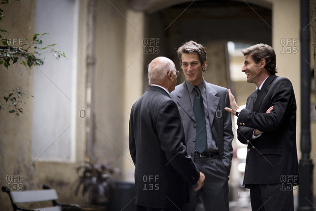 View of three businessmen in conversation.