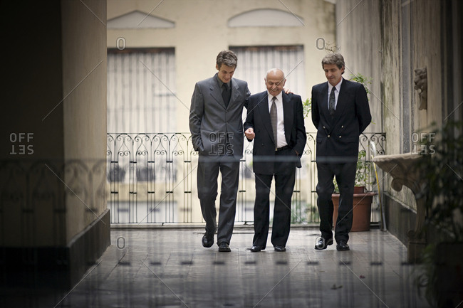 View of three men walking in a balcony.