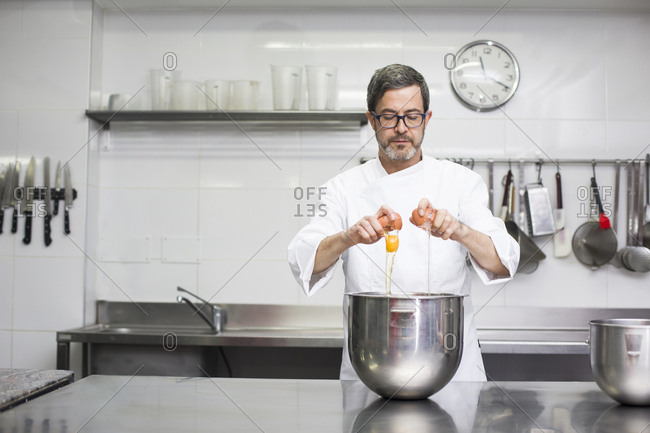 Chef breaking eggs in bowl