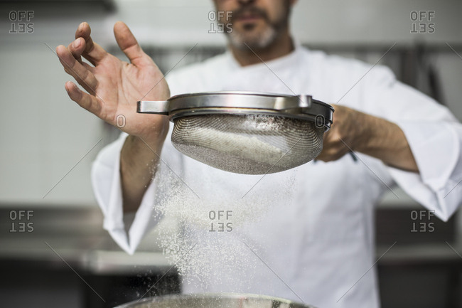 Chef sifting flour into bowl