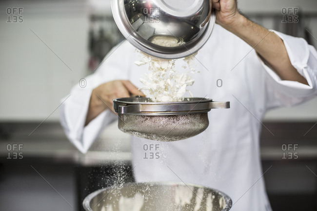 Chef sifting flour into bowl