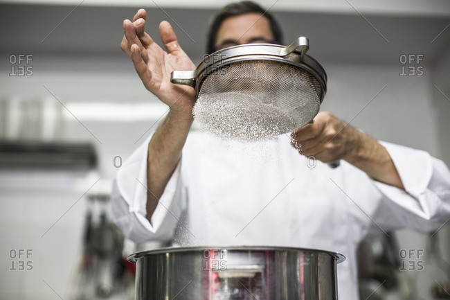 Chef sifting flour into bowl