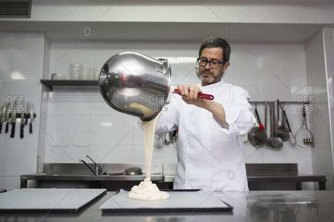 Chef putting dough out of bowl on cooking tray