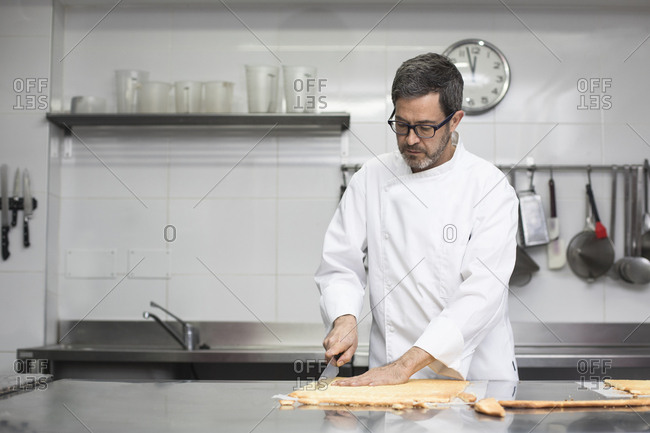 Chef cutting cake layer in kitchen