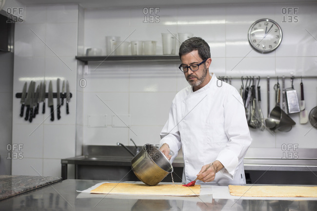 Chef soaking biscuit with syrup making pastry