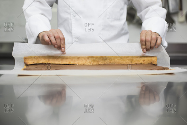 Male chef making cake roll