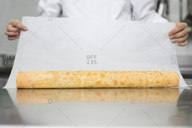 Chef preparing pastry roll with baking paper