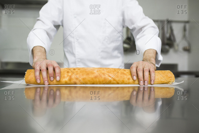 Male chef making cake roll