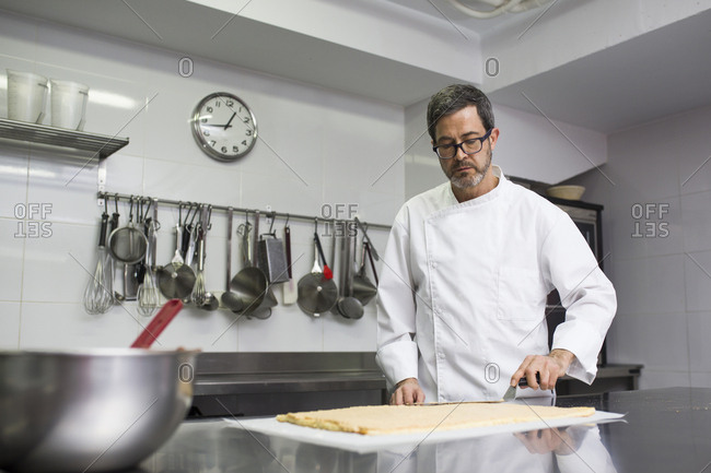 Concentrated chef spreading cream on biscuit layer