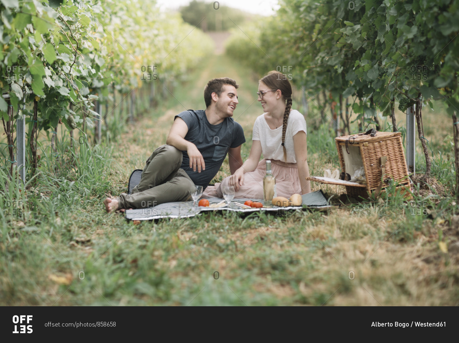 Happy young couple having picnic in the vineyards