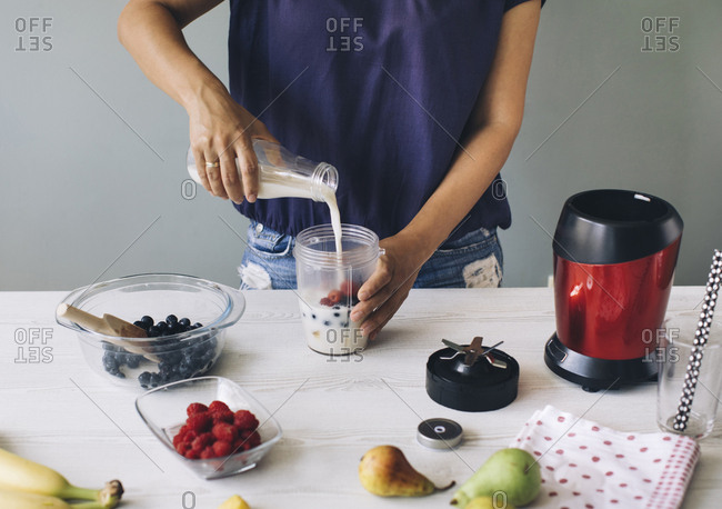 Woman mixing ingredients for a smoothie