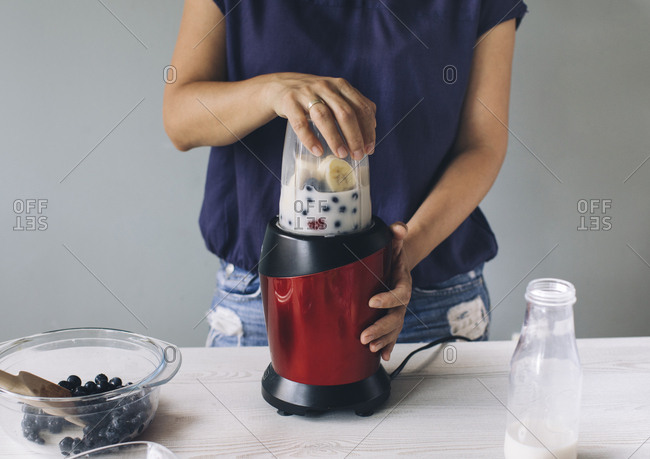 Woman making smoothie in a blender