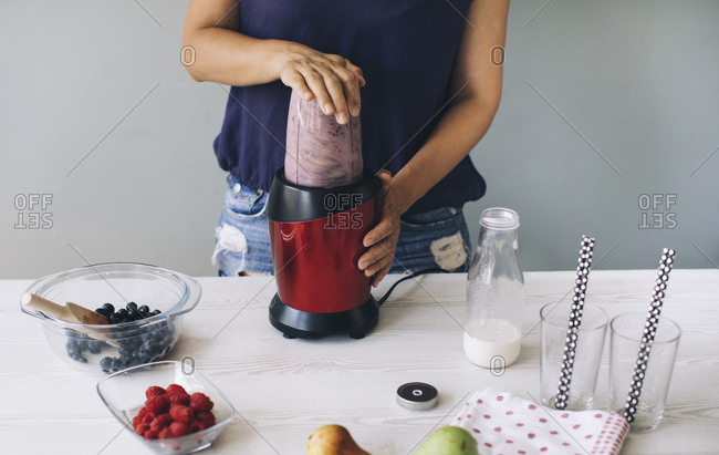 Woman making smoothie in a blender