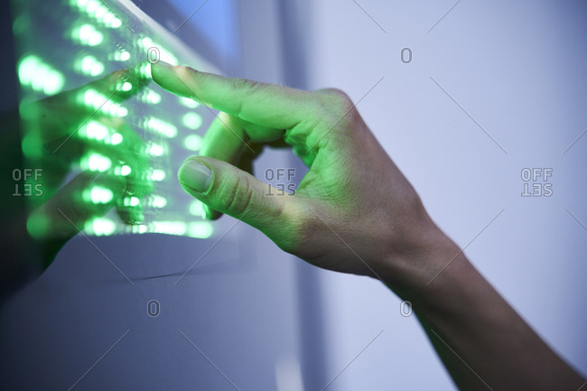 Detail of finger touching green led touchscreen