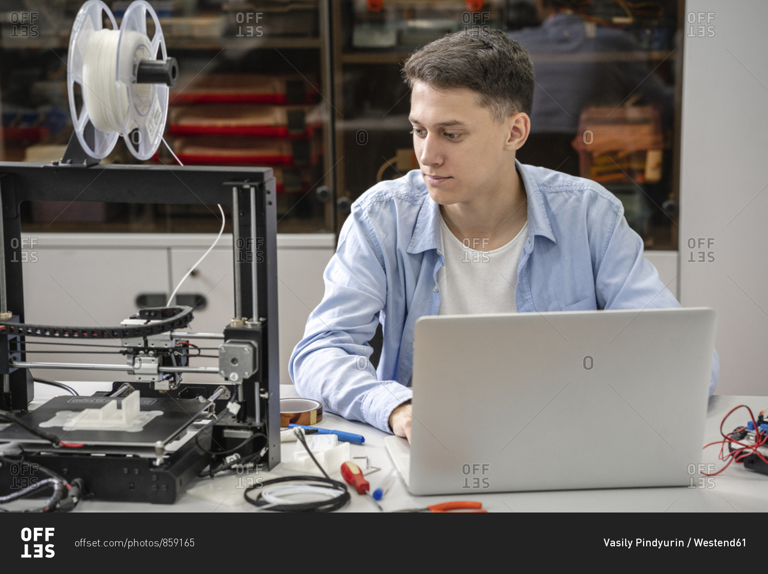 Student setting up 3D printer- using laptop
