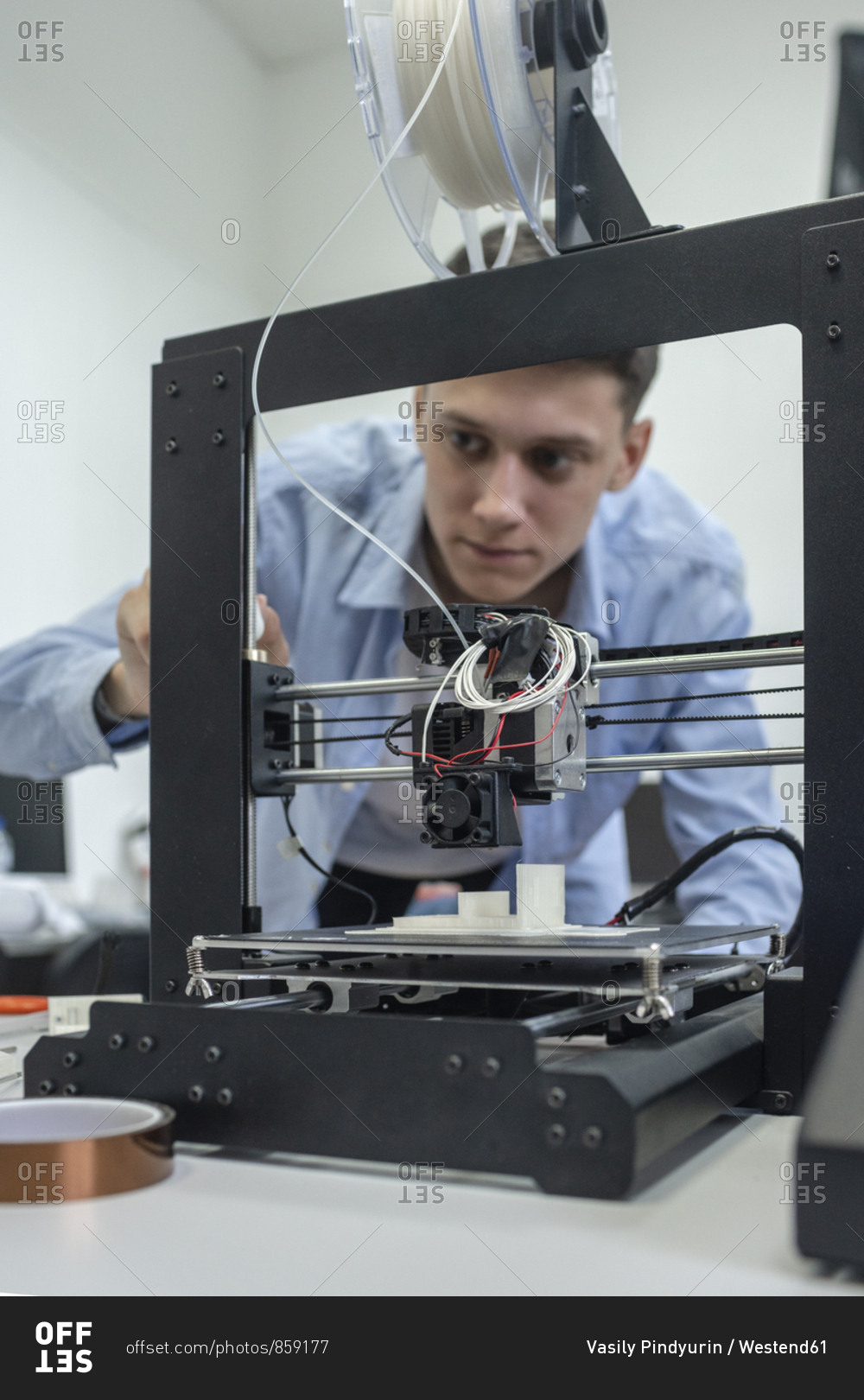 Student setting up 3D printer- using laptop