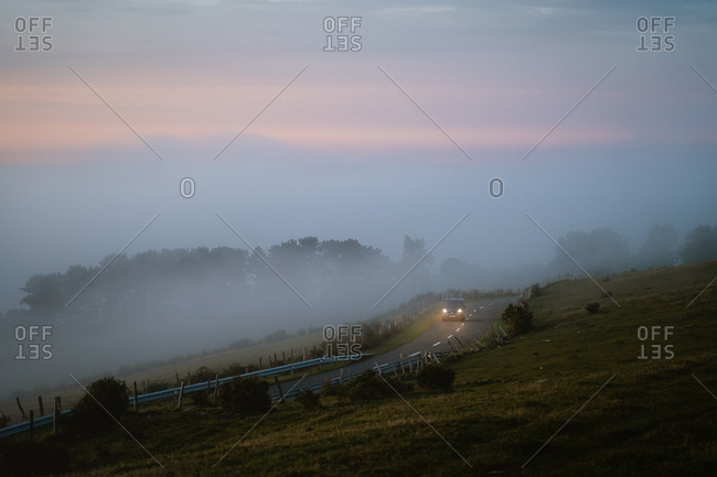 Gipuzkoa, Spain - September 13, 2019: Camper van driving through foggy road by the ocean during sunset