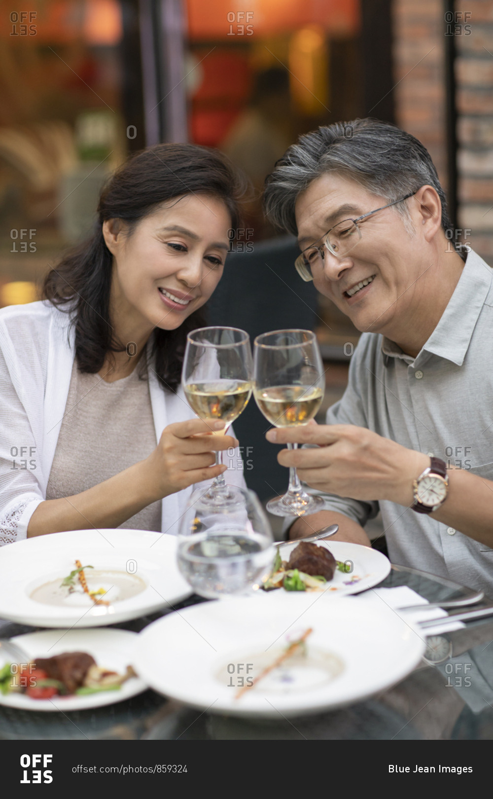 Mature Chinese couple toasting at restaurant