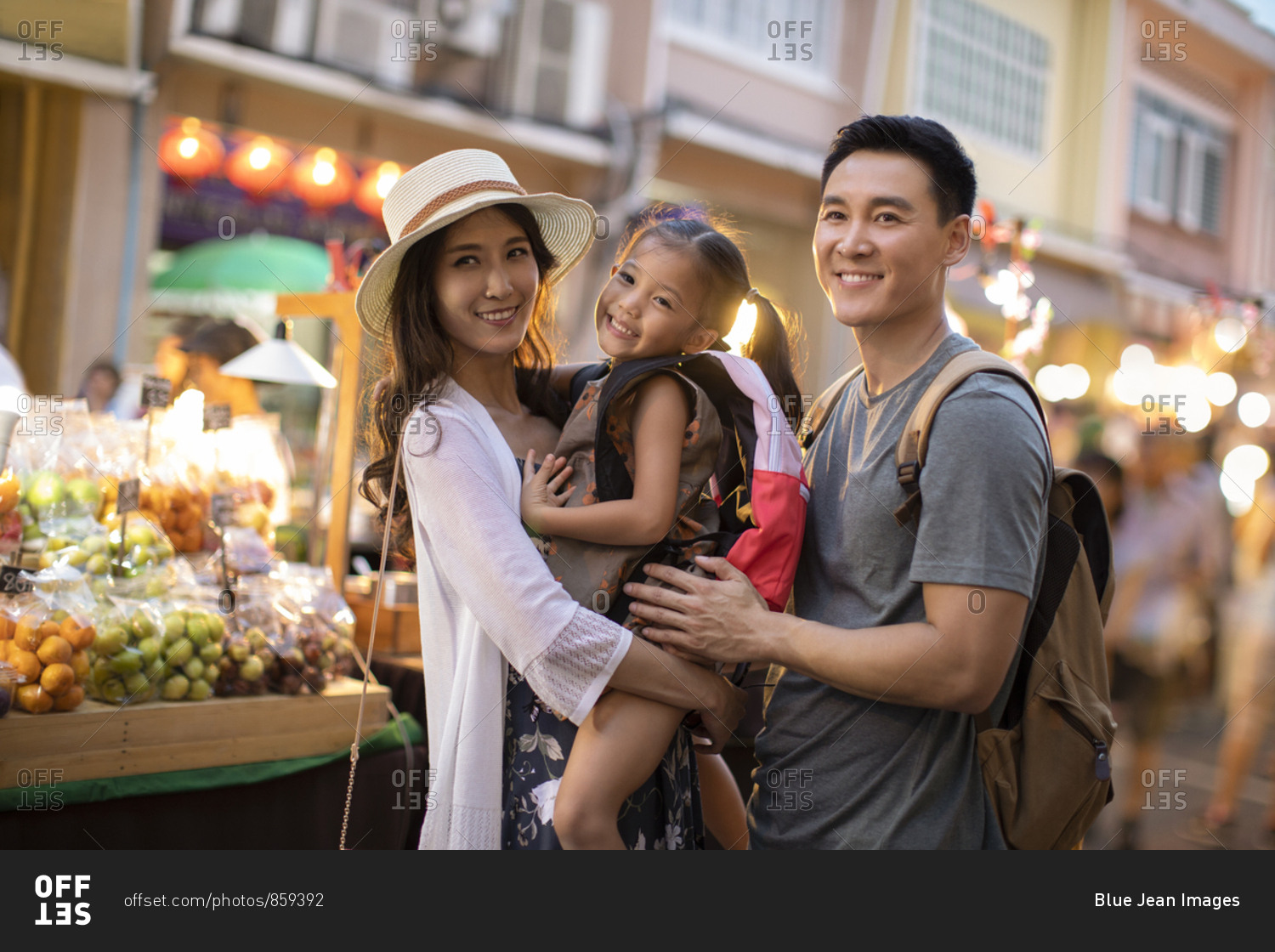 Happy young Chinese family relaxing in street market