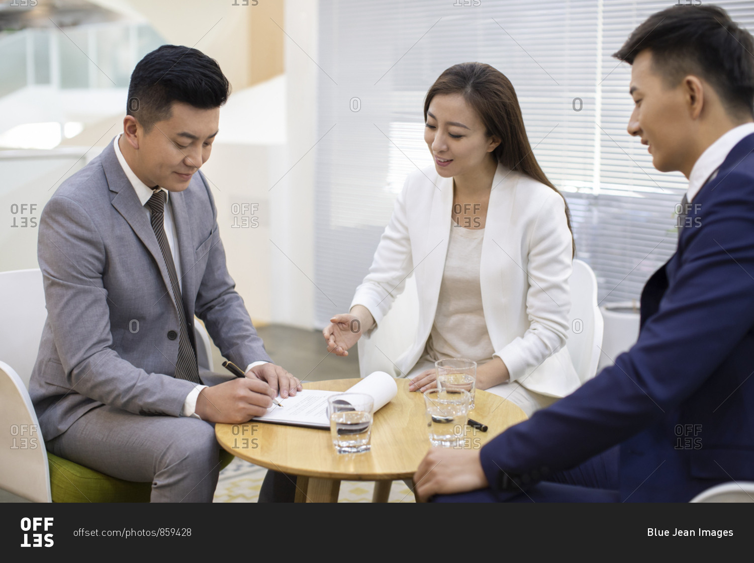 Chinese business people signing contract in office