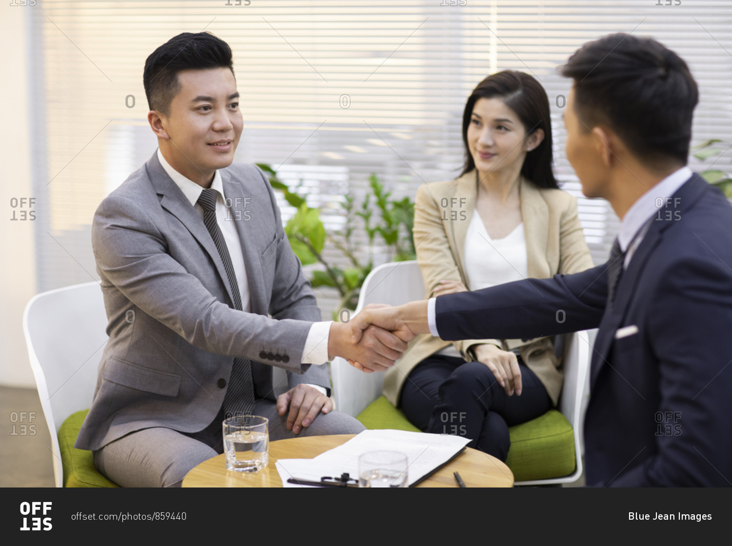 Chinese business people shaking hands in office