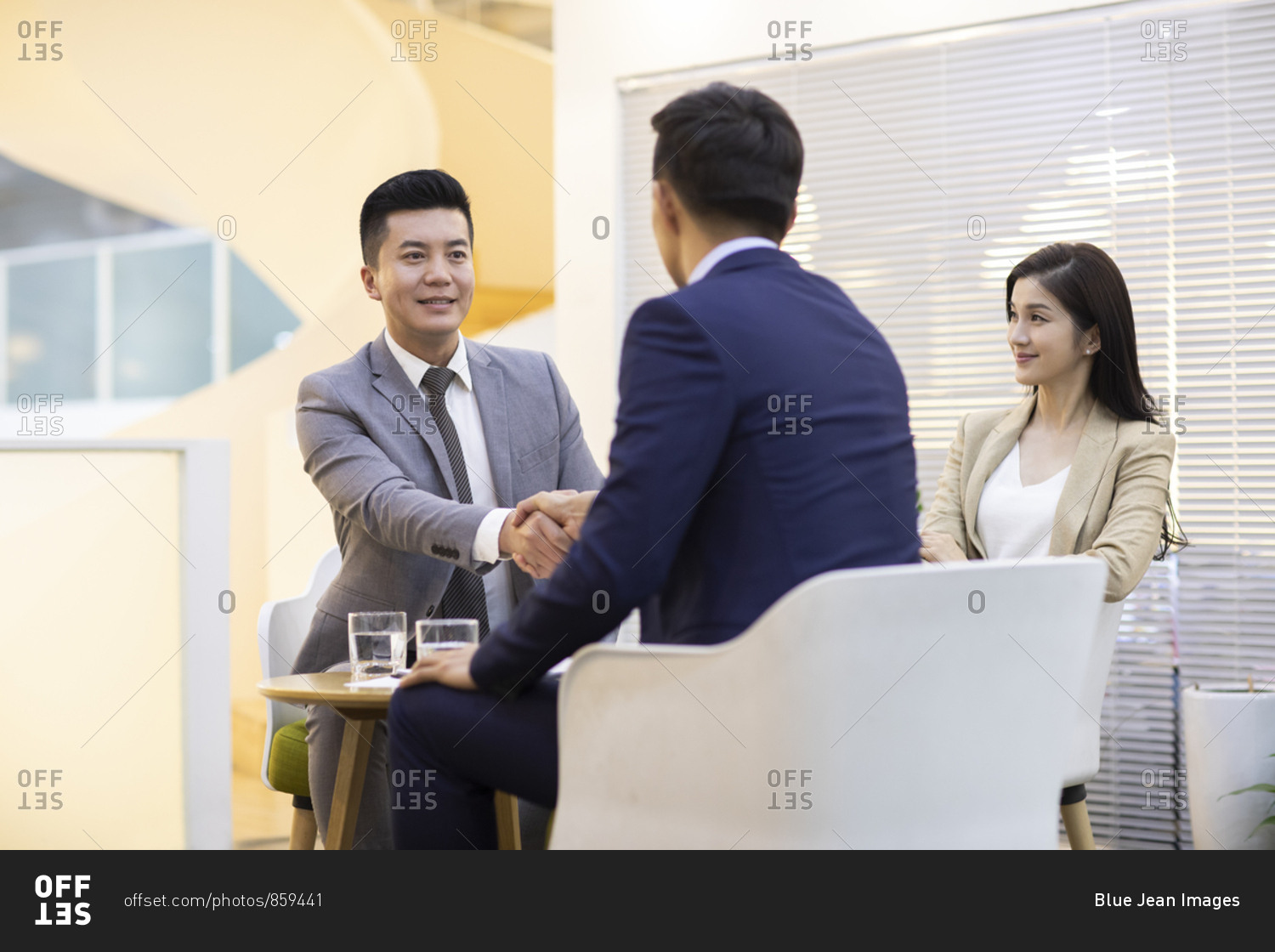 Chinese business people shaking hands in office