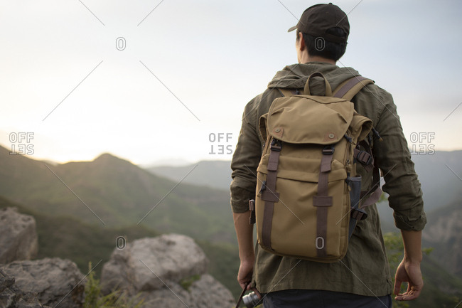 Young Chinese man standing on mountain peak