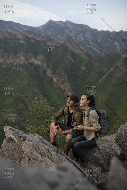 Young Chinese couple taking photos with camera outdoors