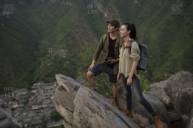 Young Chinese couple taking photos with camera outdoors