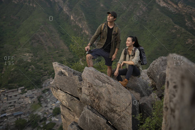 Young Chinese couple taking photos with camera outdoors