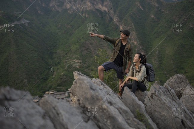 Young Chinese couple taking photos with camera outdoors