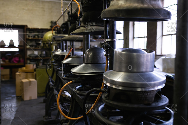 Side view of a row of old machines used in the process of making hats in the workshop at a hat factory
