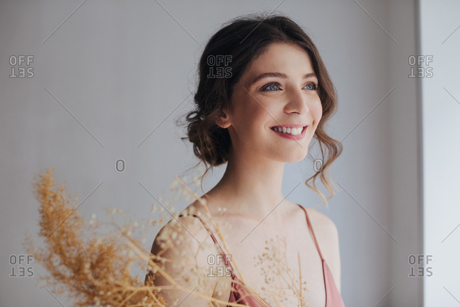 Portrait of beautiful tender young smiling woman in silky nightgown.