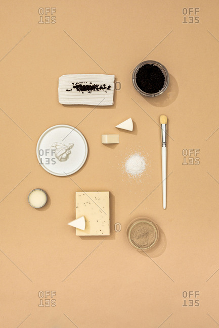 Minimalistic composition of natural soaps and cosmetic creams and scrubs and spa products on pastel background.