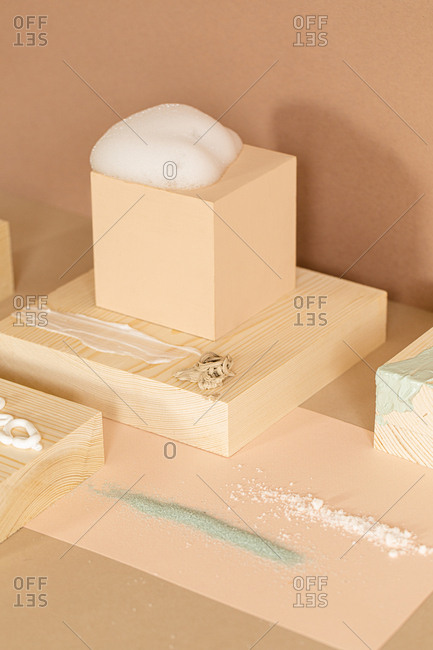 Composition of soap foam scrubs and cream on wooden objects.