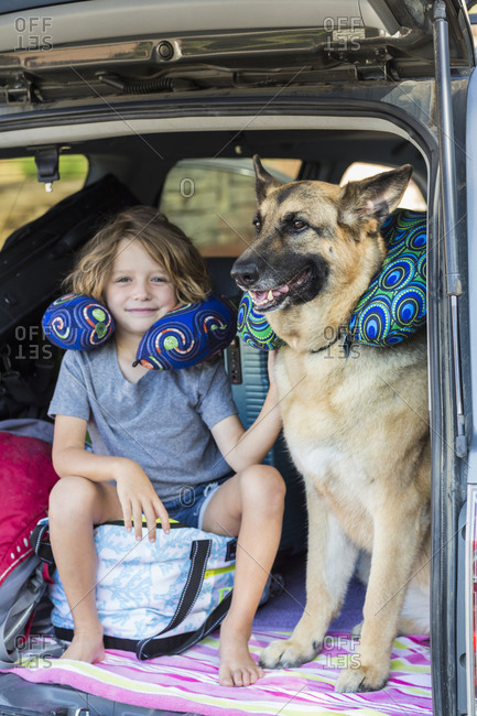 5 year old boy with his German Shepherd dog, in back of  SUV