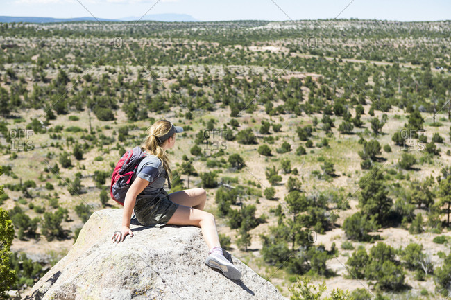 Rear view of a teenage girl hiker overlooking desert vista