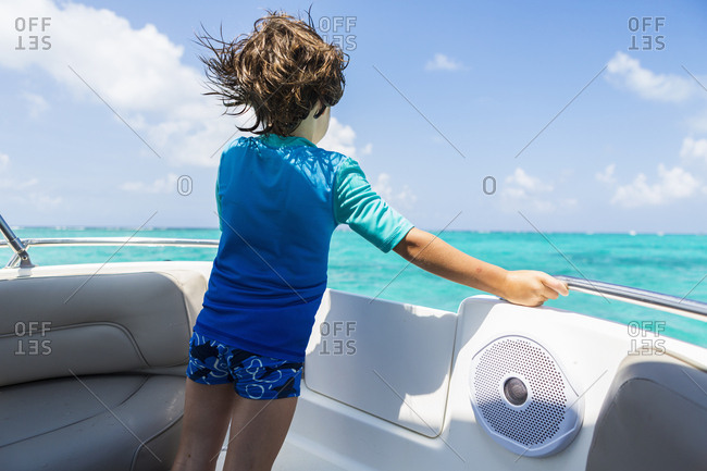 5 year old boy on a boat looking at the ocean