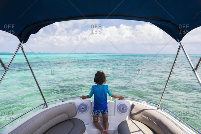 5 year old boy on a boat looking at the ocean