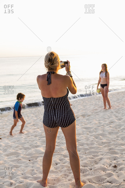 mother and her children enjoying the beach at sunset