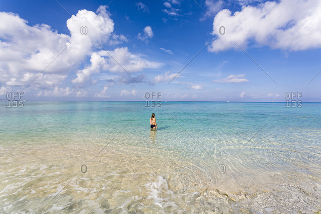 A teenage girl standing in the ocean