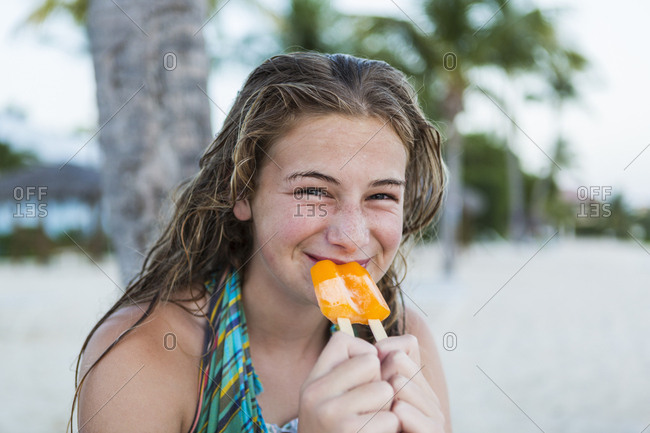 A teenage girl eating a popsicle on holiday