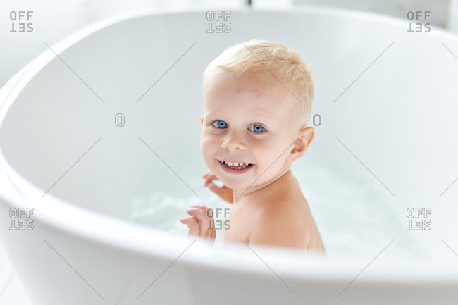 Blue Eyed Blonde Haired Baby Boy In Modern Bathtub Stock Photo