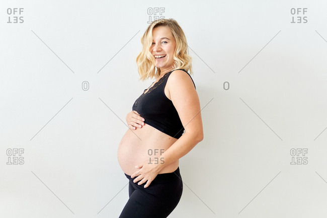 Smiling Pregnant Woman Dressed In Black Showing Her Bare Belly Stock Photo Offset