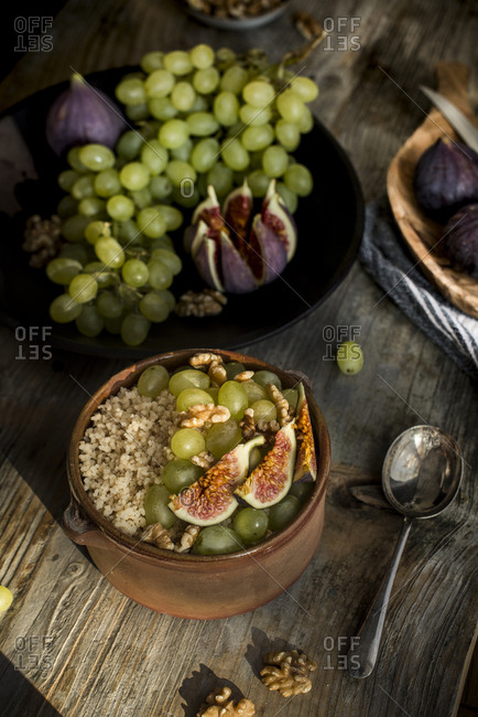 Tunisian couscous called masfouf with fresh fig, raisins, and walnuts in a pottery bowl