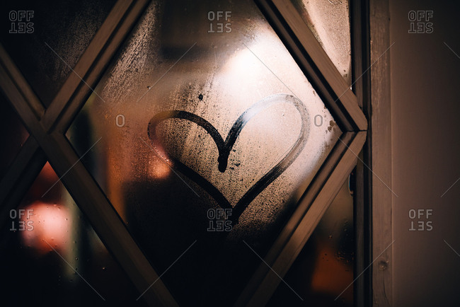 Heart drawn on foggy glass of a door