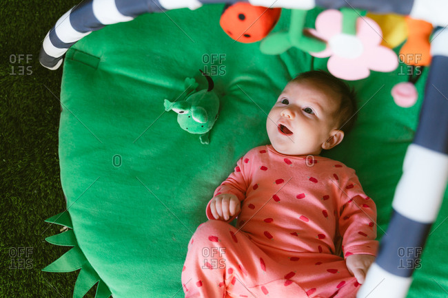 Happy baby girl playing on a child play mat